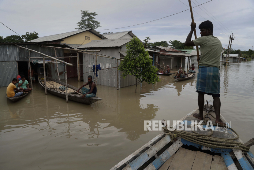  Seorang lelaki yang terkena dampak banjir India mengayuh sebuah perahu dekat rumah-rumah yang terendam sebagian di desa Gagolmari, distrik Morigaon, Assam, India, Selasa, 14 Juli 2020. Ratusan ribu orang terkena dampak banjir dan tanah longsor setelah curah hujan yang tak henti-hentinya menyusul hujan yang tak henti-hentinya di wilayah itu. Miris, Muslim di Assam India Dituding Jadi Penyebab Banjir