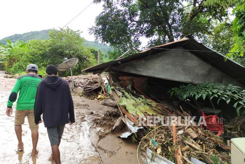 Warga melintas di dekat rumah yang rusak akibat banjir bandang di Adonara Timur, Flores Timur, NTT, Senin (5/4/2021). Berdasarkan data BNPB hingga senin siang, korban meninggal dunia akibat banjir bandang di Flores Timur mencapai  68 jiwa.