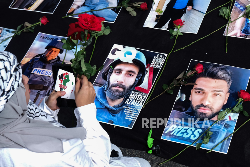 Warga menaruh bunga mawar di atas sejumlah foto jurnalis Gaza, Palestina yang tewas saat bertugas pada aksi damai di Solo, Jawa Tengah, Ahad (17/12/2023).