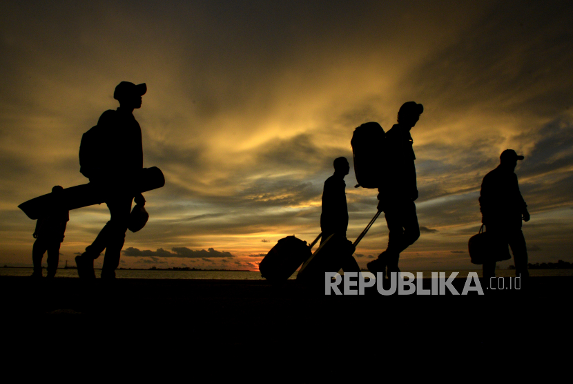 Calon penumpang berjalan sambil mengangkat barangnya saat akan menaiki kapal di Pelabuhan Sukarno Hatta, Makassar, Sulawesi Selatan.