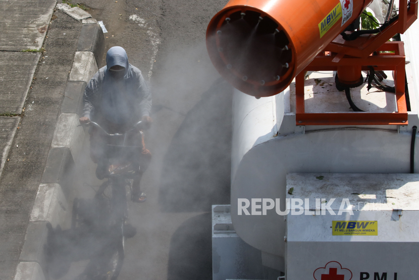 Petugas Palang Merah Indonesia (PMI) menyemprotkan larutan disinfektan di Jalan Kedung Cowek, Surabaya, Jawa Timur, Selasa (2/6/2020). Penyemprotan di sejumlah kawasan itu guna terus menekan penyebaran virus Corona (COVID-19) di Surabaya