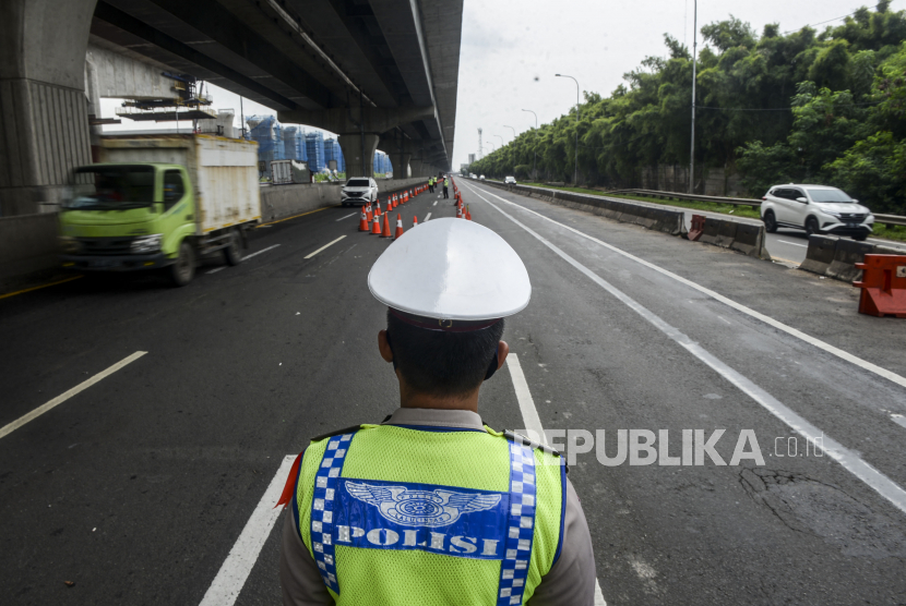 Sejumlah polisi mengawasi kendaraan yang melintas saat penerapan pelarangan mudik di tol Jakarta-Cikampek, Cikarang.