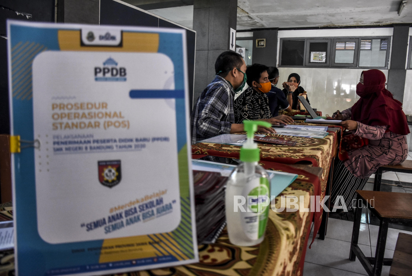 Orang tua siswa menanyakan informasi kepada petugas Penerimaan Peserta Didik Baru (PPDB) di SMKN 8 Bandung, Jalan Kliningan, Kota Bandung, Kamis (4/6). Kuota Penerimaan Peserta Didik Baru (PPDB) Kota Bandung periode 2020/2021 sebanyak 9