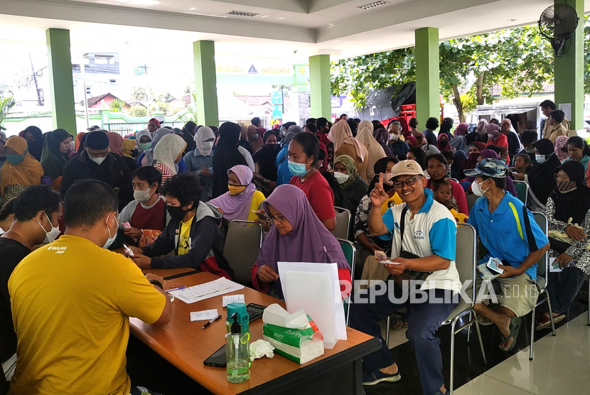 Warga antre untuk membeli sembako saat Pasar Murah di Kantor Kecamatan Gamping, Sleman, Yogyakarta, Senin (20/2/2023). 