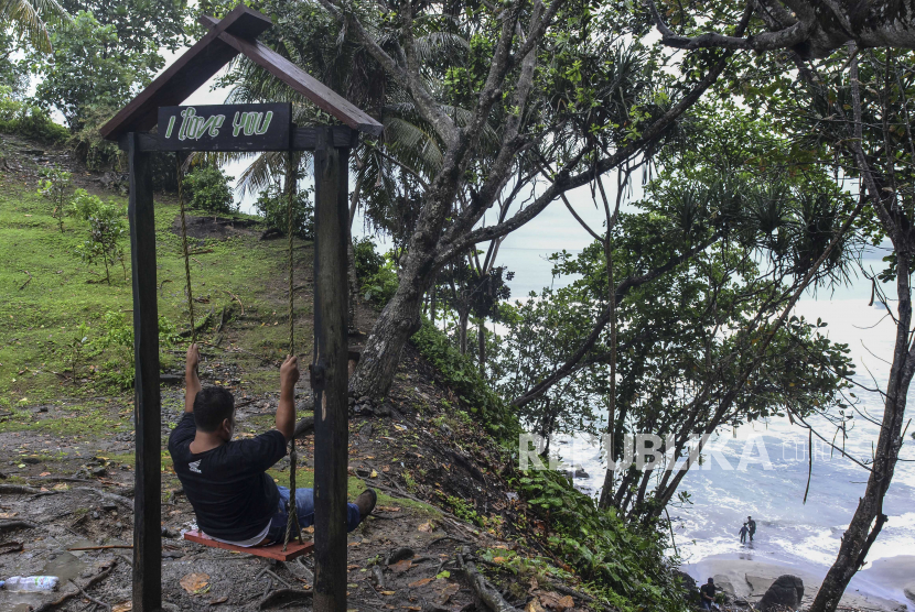 Wisatawan menikmati Pantai Karang Nini di Resort Pemangkuan Hutan (RPH), Desa Emplak, Kabupaten Pangandaran, Jawa Barat, Ahad (25/10/2020). Wisata Karang Nini menyuguhkan pemandangan keindahan hutan dan lautan serta tersedian juga area perkemahan. 