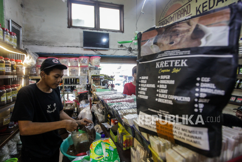 Pedagang membungkus tembakau untuk pembeli di Kedai Tembakau Kemang, Bangka, Jakarta, Senin (25/12/2023). 