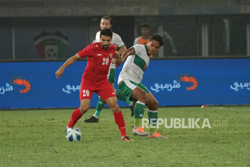 Pesepak bola Timnas Indonesia Fachruddin Aryanto (kanan) berebut bola pesepak bola Timnas Yordania Monther Abu Amara (kiri) pada laga lanjutan Grup A Kualifikasi Piala Asia 2023 di Stadion Internasional Jaber Al Ahmad, Kuwait, Sabtu (11/6/2022). Indonesia kalah dengan skor 0-1. 