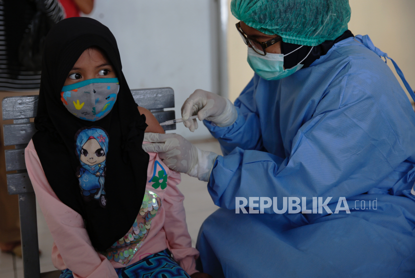  Seorang dokter memvaksinasi seorang gadis muda di sebuah sekolah dasar Muslim di Depok, Indonesia, 20 November 2020. Banyak sekolah di Indonesia memberikan vaksin campak, difteri dan tetanus, kepada siswa sekolah dasar di tengah pandemi virus corona yang sedang berlangsung.