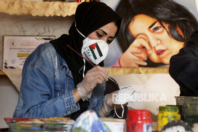 Seniman Palestina Samah Saed menghiasi masker dengan gambar kartun, untuk mendorong orang agar memakainya sebagai tindakan pencegahan terhadap coronavirus, di sebuah lokakarya di lingkungan Shijaiyah Gaza, Kamis, 2 April 2020. Pengepungan dan Covid-19 memperburuk kondisi perekonomian Gaza. Ilustrasi.