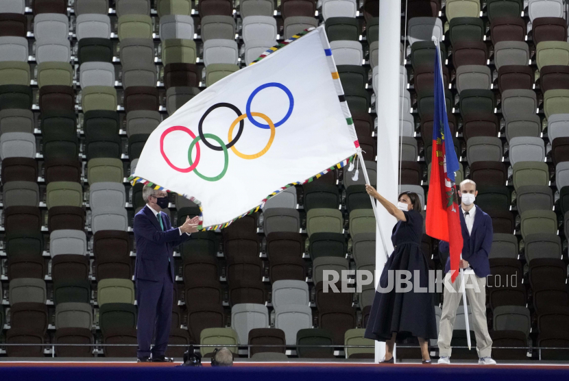  Anne Hidalgo, Wali Kota Paris, memegang bendera Olympian sementara Presiden Komite Olimpiade Internasional Thomas Bach berdiri di sebelah kiri saat upacara penutupan di Stadion Olimpiade pada Olimpiade Musim Panas 2020, Minggu, 8 Agustus 2021, di Tokyo, Jepang. IOC serukan semua federasi dan penyelenggara olahraga depak Rusia dan Belarusia.