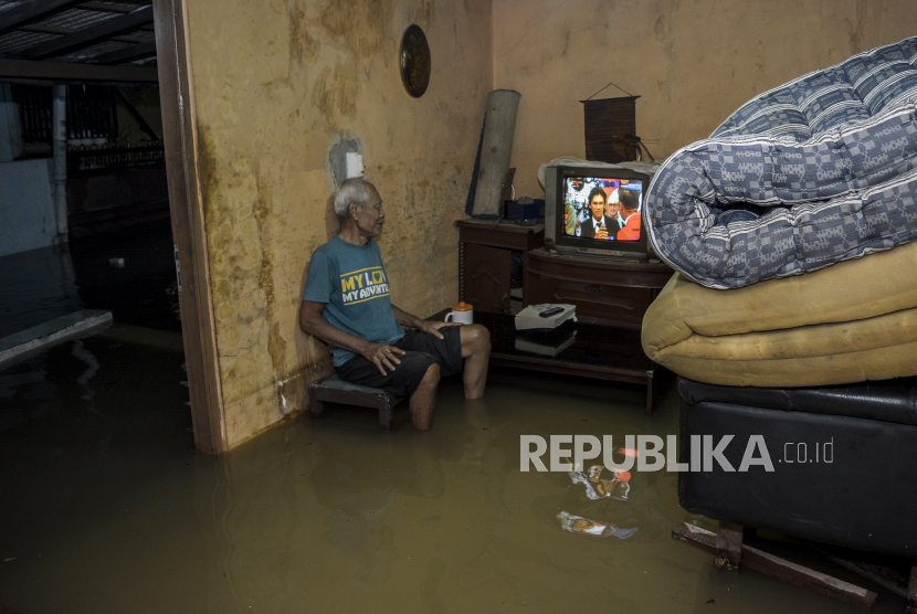 Warga menonton televisi di rumahnya yang terendam banjir di Jalan Inpres 2, Larangan Utara, Ciledug, Tangerang, Banten. BPBD sebut sebanyak 445 KK di Kabupaten Tangerang terendam banjir.