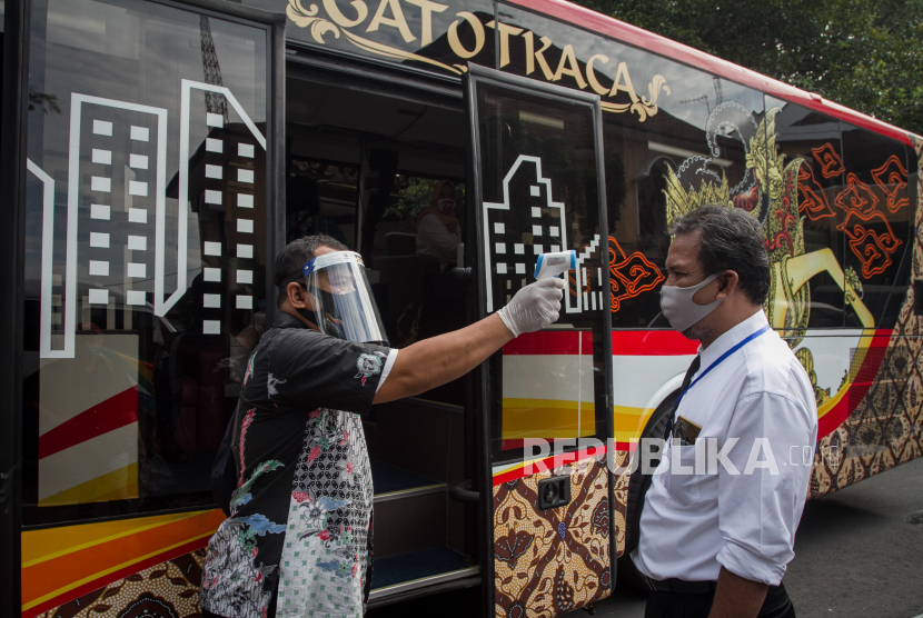 Petugas Dinas Perhubungan mengenakan pelindung wajah (face shield) dan sarung tangan sebelum bertugas di dalam Bus Gatotkaca di Solo, Jawa Tengah, Jumat (3/7/2020).