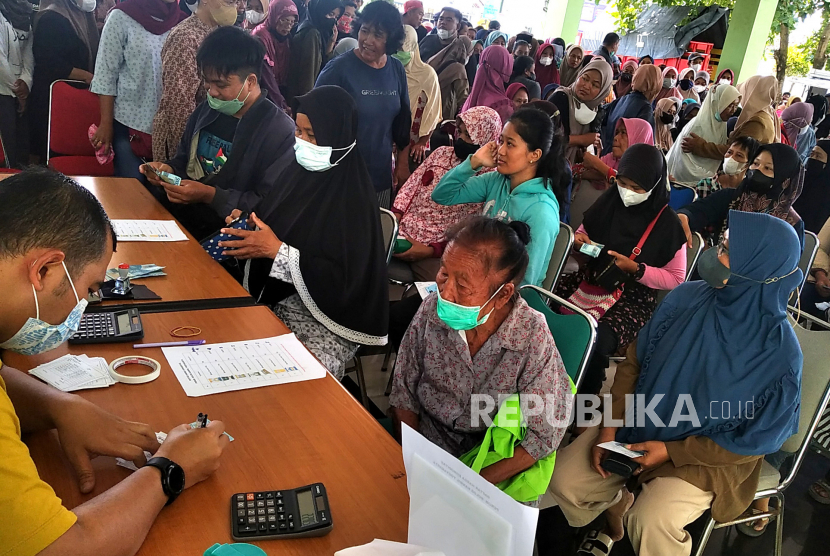 Warga antre untuk membeli sembako saat Pasar Murah di Kantor Kecamatan Gamping, Sleman, Yogyakarta, Senin (20/2/2023). Pasar murah yang diadakan oleh Bulog DIY bersama Pemkab Sleman ini menjual sembako dengan harga murah,  seperti beras, Minyakita, tepung terigu, dan gula pasir. Untuk beras ada 17 ton yang akan disebar di 17 titik kecamatan. Pasar murah ini sebagai upaya untuk menekan inflasi dan menjaga ketersediaan stok bahan pangan pokok. Namun, pasar murah ini hanya diperuntukkan untuk warga ber-KTP Sleman dan pembatasan maksimal pembelian beras medium 10 kilogram, beras premium 20 kilogram, gula 5 kilogram, minyak goreng 2 liter, dan tepung terigu 5 kilogram.