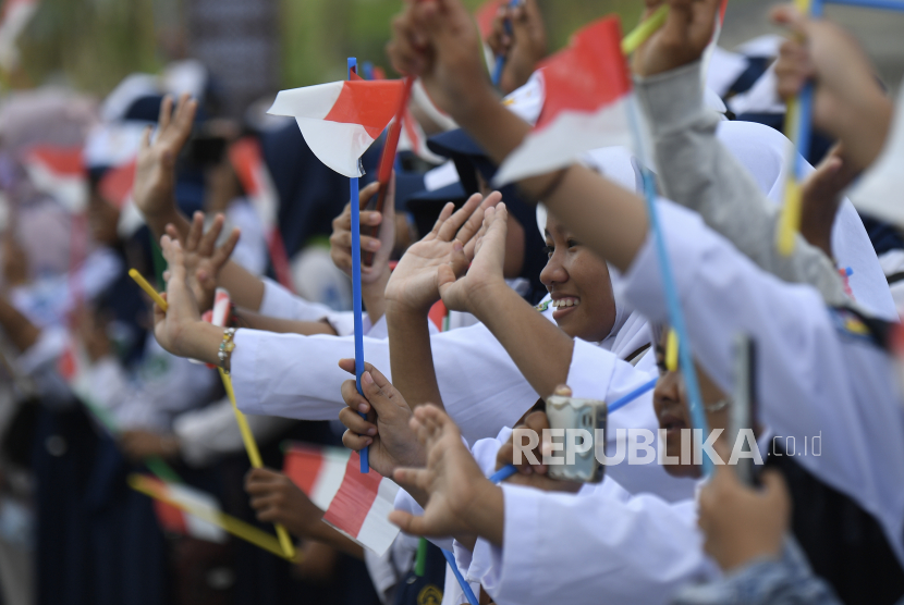 Sejumlah pelajar melambaikan tangan ke arah iring-iringan pembawa duplikat bendera Pusaka Merah Putih dan salinan naskah teks proklamasi saat meninggalkan Istana Negara Ibu Kota Nusantara (IKN).