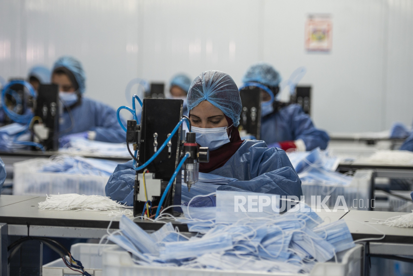 Pekerja di sebuah pabrik yang memproduksi masker bedah, di Kairo, Mesir, 14 Juni 2020. Negara-negara di seluruh dunia mengambil langkah-langkah peningkatan untuk membendung penyebaran virus corona SARS-CoV-2 yang menyebabkan penyakit Covid-19. Mesir Umumkan Pembatasan Perjalanan di Bandara