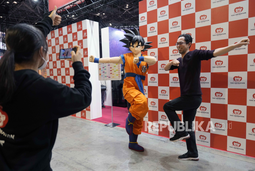 Pengunjung berpose dengan cosplayer berkostum Son Goku, karakter Dragon Ball, pada AnimeJapan 2024 di Tokyo, Jepang, 23 Maret 2024. Taman hiburan Dragon Ball pertama di dunia dibangun di Arab Saudi.