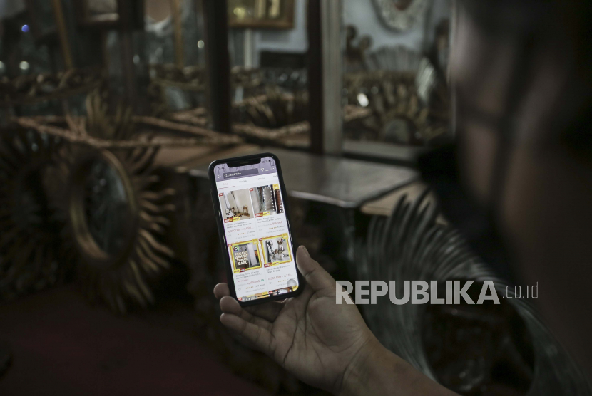 Pedagang cermin mengamati produk yang dipasarkannya di aplikasi jual beli di kawasan Pejompongan, Jakarta, Ahad (8/8/2021). 
