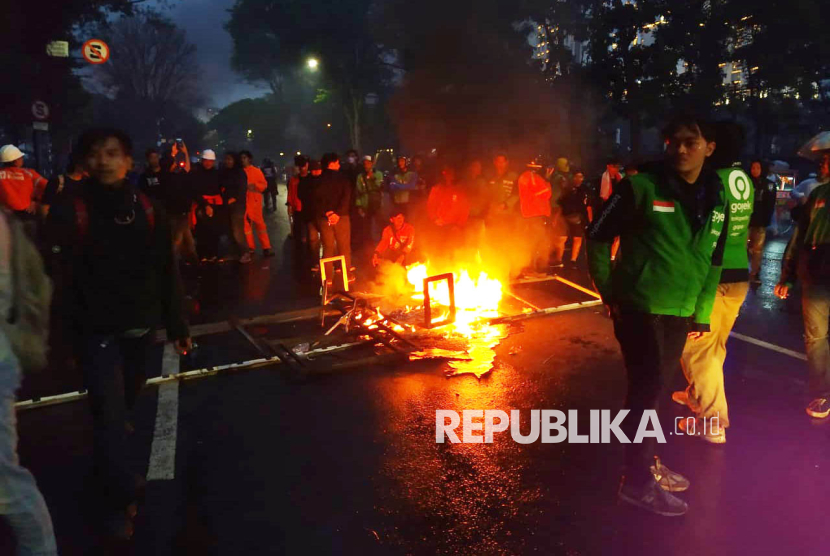 Sejumlah pengemudi ojek online (ojol) bertahan sampai malam saat aksi demonstrasi di Gedung DPRD Provinsi Jabar, Jalan Diponegoro, Kota Bandung, Jumat (29/8/2025). Aksi demo yang dilakukan mahasiswa, pelajar dan pengemudi ojek online (ojol) ini sebagai bentuk solidaritas atas meninggalnya Affan Kurniawan, pengemudi ojol yang meninggal dilindas mobil taktis Brimob, serta menyikapi sejumlah kebijakan DPR RI yang dianggap tidak pantas.
