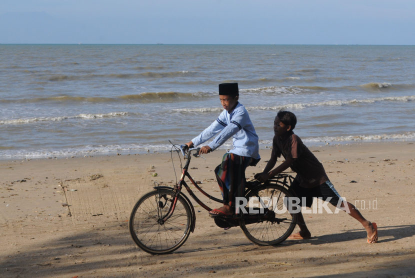 Anak-anak bermain sepeda di Pantai Jumiang, Pamekasan, Jawa Timur, Senin (27/4/2020). Fungsi kontrol dan pengawasan orang tua sangat dibutuhkan untuk mencegah mereka bermain di luar, ditengah pandemi COVID-19 seperti saat ini
