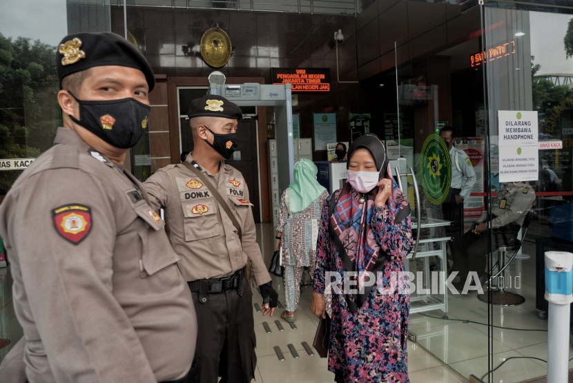 Petugas Kepolisian berjaga di depan pintu masuk ruangan persidangan terdakwa kasus dugaan tindak pidana teroris Munarman di Pengadilan Negeri Jakarta Timur.