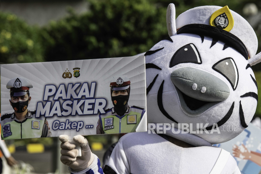 Petugas Ditlantas Polda Metro Jaya menggunakan kostum binatang membawa poster sosialisasi untuk menggunakan masker di kawasan Bundaran HI, Jakarta, Minggu (4/10/2020). Kegiatan tersebut untuk mengajak warga agar disiplin mengenakan masker dan menerapkan protokol kesehatan untuk menekan penyebaran COVID-19. 