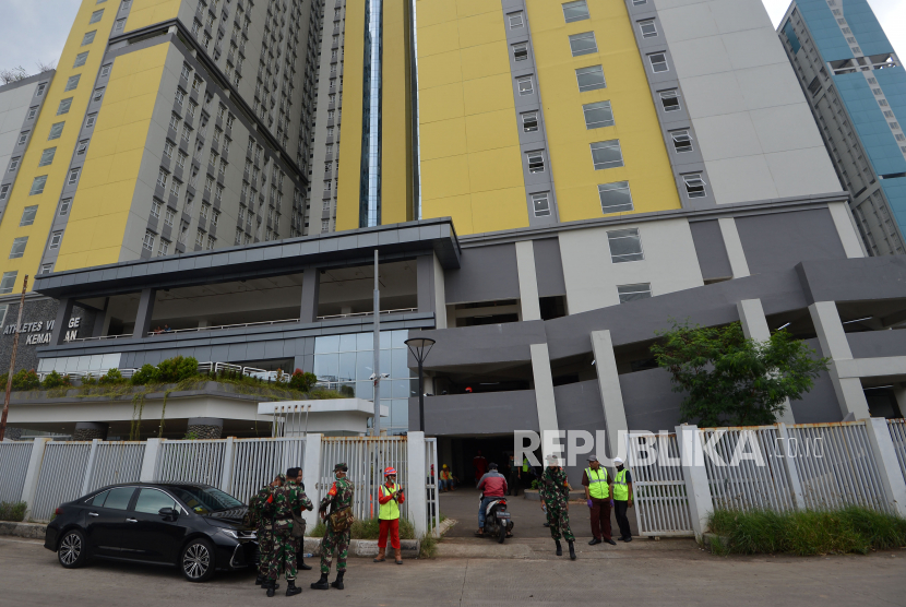Sejumlah petugas berjaga di depan Wisma Atlet, Kemayoran, Jakarta, Kamis (19/3/2020). Dua menara Wisma Atlet Kemayoran siap menampung pasien Covid-19 mulai Senin (23/3) mendatang. (Antara/Aditya Pradana Putra)