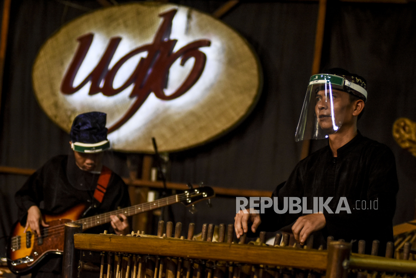 Sejumlah personil band mengenakan pelindung wajah saat tampil pada pertunjukan Bamboo Afternoon Show di Saung Angklung Udjo, Jalan Padasuka, Kota Bandung, Sabtu (27/6/2020). Sejak pandemi, kunjungan wisatawan ke Saung Angklung Udjo turun drastis.