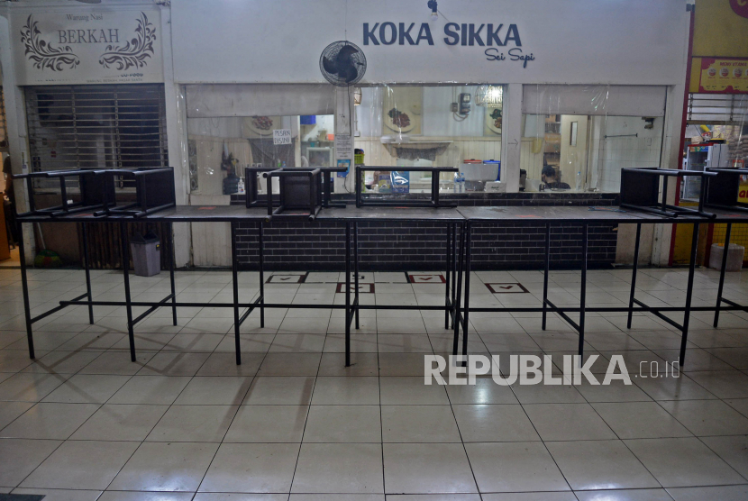 Selama PPKM Darurat, pedagang kuliner hanya dibolehkan melayani pesanan take away sehingga bangku dan meja harus dirapikan di area Food Court Pasar Santa, Jakarta Selatan, Ahad (18/7)