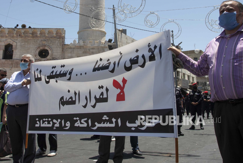  Para pemrotes Yordania memegang plakat bertuliskan dalam bahasa Arab 