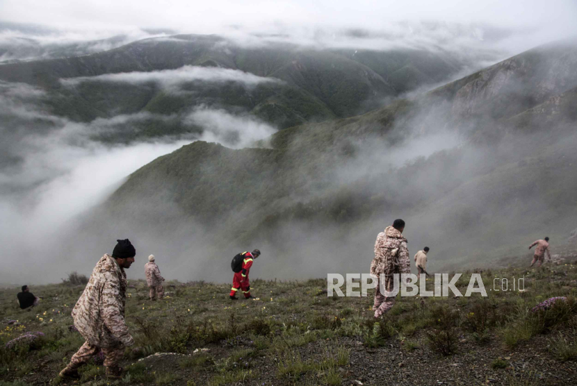 Tim evakuasi berusaha mengangkat puing-puing helikopter yang jatuh saat menangkut Presiden Iran Ebrahim Raisi. 