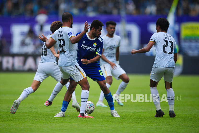 Gelandang Persib Bandung Riky Kambuaya berusaha melepaskan diri dari kepungan lawan pada laga antara Persib Bandung melawan Rans Nusantara FC di Stadion GBLA, Bandung, Ahad (4/9/2022). Laga berakhir dengan skor 2-1 untuk kemenangan Tim Persib Bandung.