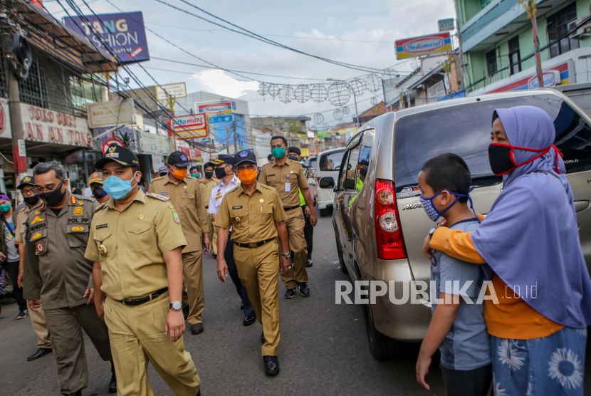 Tersisa Lima RW Zona Merah di Tangerang. Wali Kota Tangerang Arief Wismansyah (kedua kiri) meninjau pelaksanaan Pembatasan Sosial Berskala Besar (PSBB),  di kawasan rawan keramaian di Pasar Anyar, Kota Tangerang, Banten, Selasa (5/5/2020). Walikota Tangerang meminta masyarakat untuk selalu menggunakan masker dan menerapkan physical distancing saat keluar rumah agar pelaksanaan PSBB di Kota Tangerang berjalan efektif