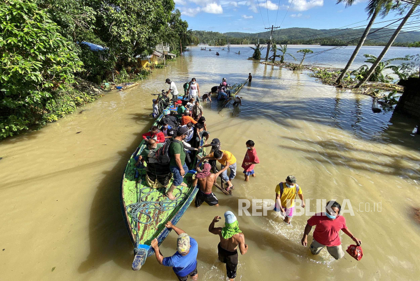 Sekelompok pengendara yang terdampar turun dari perahu di jalan yang banjir setelah Topan Vamco di kota Lopez, provinsi Quezon, Filipina.(Ilustrasi)