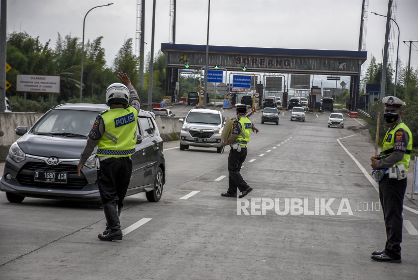 Anggota Satlantas Polresta Bandung memberhentikan pengendara saat operasi penyekatan dan pemeriksaan di Gerbang Keluar Jalan Tol Soreang, Kabupaten Bandung.