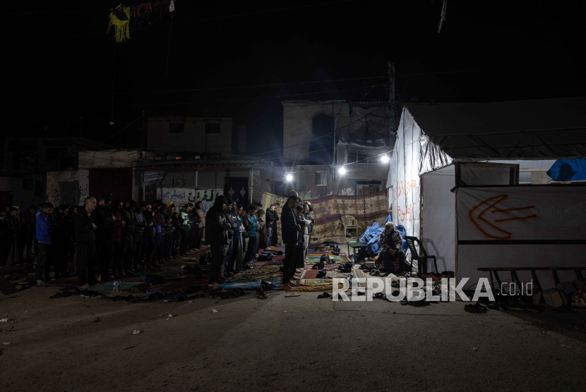 Pengungsi Palestina melaksanakan salat Lailatul Qadr selama bulan suci Ramadhan di samping reruntuhan masjid, di Rafah, Jalur Gaza selatan, (6/4/2024).