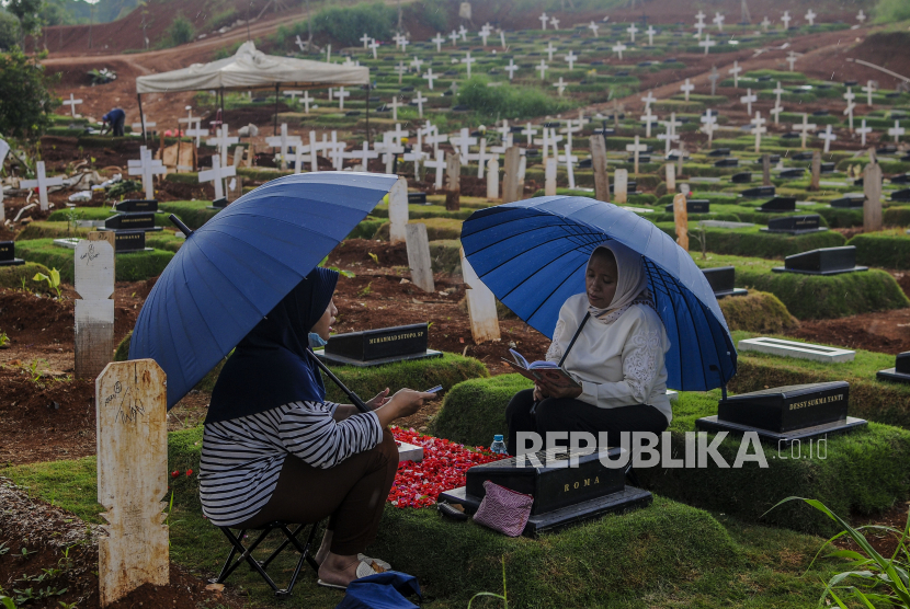 Warga berziarah di area pemakaman jenazah Covid-19 di TPU Pondok Ranggon, Jakarta Timur, Rabu (2/12).
