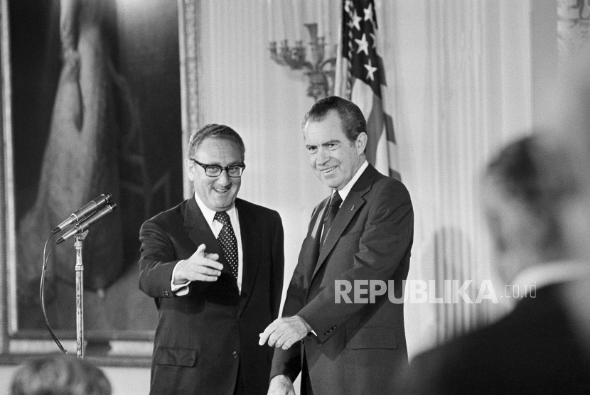 Menteri Luar Negeri Henry Kissinger, kiri, memberi isyarat kepada hadirin di Ruang Timur Gedung Putih, 22 September 1973, saat Presiden Richard Nixon menyaksikan, di Washington. 