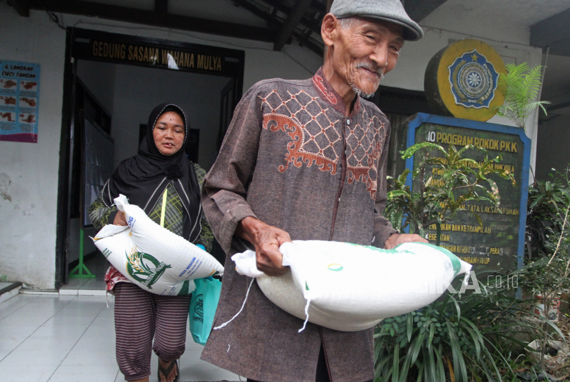 Sejumlah Keluarga Penerima Manfaat (KPM) membawa beras yang diterima dalam penyaluran bantuan pangan di aula Kelurahan Bandungrejosari, Malang, Jawa Timur, Senin (5/6/2023). 