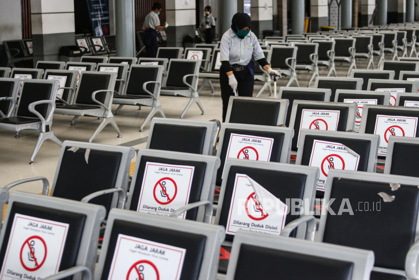 Petugas membersihkan ruang tunggu calon penumpang di Stasiun Pasar Senen, Jakarta.