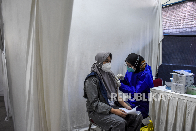 Vaksinator menyuntikkan vaksin Covid-19 ke anak saat pelaksanaan vaksinasi massal di Gedung PKK Kota Bandung