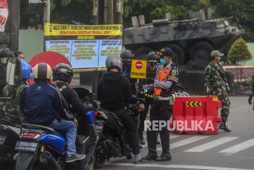 Sejumlah petugas gabungan memberikan imbauan putar balik kepada pengendara motor saat melakukan penyekatan di Jakarta Timur.