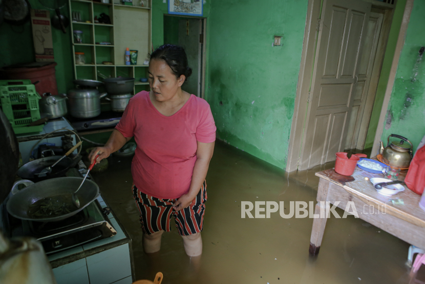 Seorang warga beraktivitas di rumahnya yang terendam banjir di kawasan Benda, Kota Tangerang, Banten. Pemkot Tangerang berencana melakukan relokasi terhadap warga korban banjir.