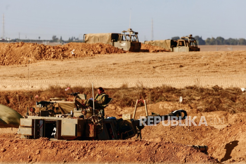 Seorang tentara Zionis Israel di atas kendaraan tempur lapis baja di lokasi yang dirahasiakan dekat perbatasan dengan Jalur Gaza, Israel selatan, Senin (30/10/2023).
