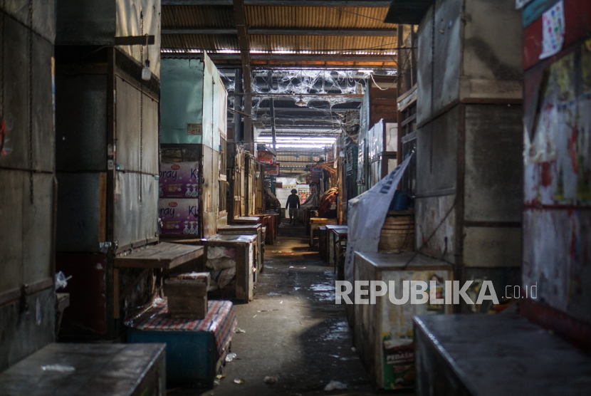 Seorang pedagang melintas di deretan kios Pasar Harjodaksino yang tutup sementara di Solo, Jawa Tengah, Selasa (14/7/2020). Pemerintah Kota Solo menutup sementara pasar tersebut selama tujuh hari kedepan setelah terdapat satu pedagang meninggal dunia terkonfirmasi COVID-19. 