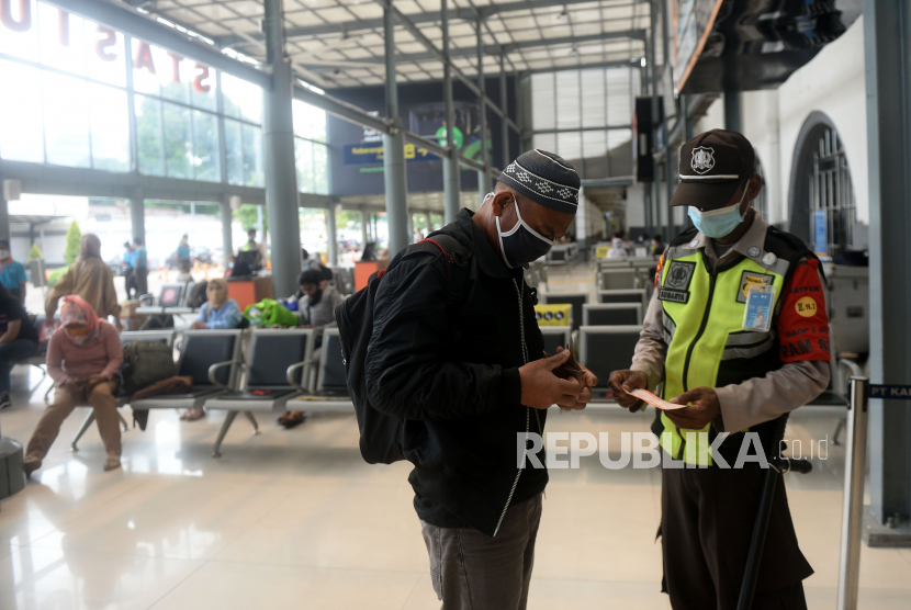 Petugas memeriksa tiket calon penumpang kereta jarak jauh di Stasiun Senen, Jakarta, Ahad (18/4). 