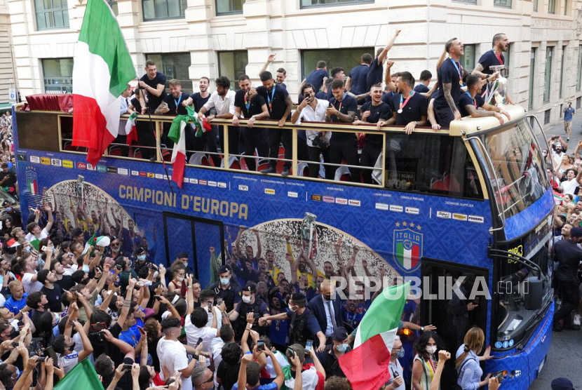 Para pemain Italia merayakan kemenangan mereka di atas bus terbuka di Roma, Senin (12/7). Dalam pertandingan final Euro 2020 yang dimainkan di stadion Wembley di London pada hari Minggu Italia mengalahkan Inggris 3-2 dalam adu penalti setelah bermain imbang 1-1. AP Photo/Gregorio Borgia