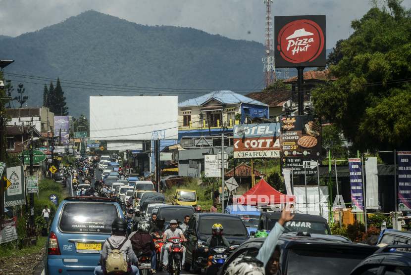 Sejumlah kendaraan terjebak kemacetan di Jalan Raya Puncak, Cisarua, Bogor, Jawa Barat, Sabtu (30/5). Kepadatan kendaraan itu diakibatkan tingginya antusias warga untuk berwisata ketika long weekend di kawasan Puncak, meskipun masih dalam masa Pembatasan Sosial Berskala Besar (PSBB)