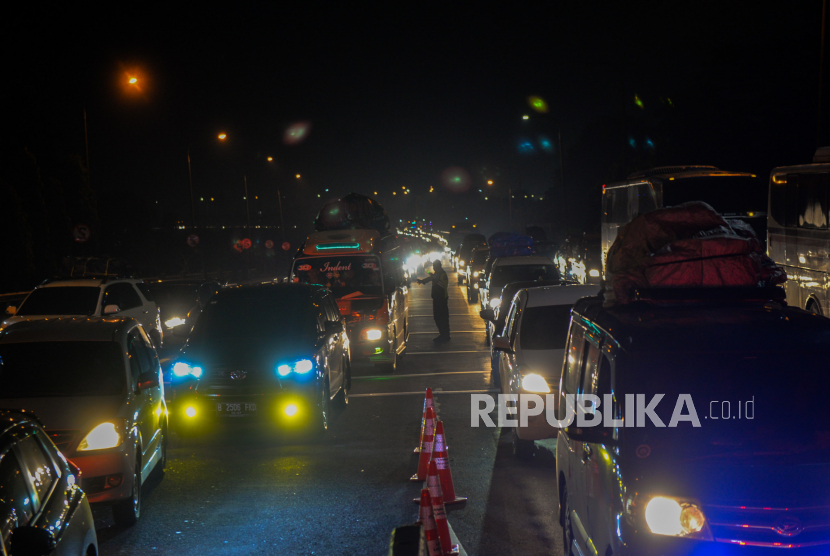 Petugas Kepolisian mengatur lalu lintas saat terjadi antrean kendaraan di Gerbang Tol Merak, Cilegon,  Banten.