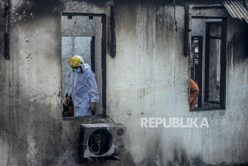 Petugas memakai baju hazmat melihat puing-puing sisa kebakaran di pasar (ilustrasi)