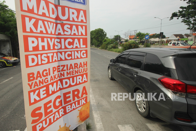Spanduk imbauan terpasang di Jalan Kedung Cowek, Surabaya, Jawa Timur. Pemasangan spanduk imbauan guna mengantisipasi penyebaran virus  Corona (COVID-19) itu untuk memberikan informasi kepada para peziarah yang menuju Pulau Madura untuk segera putar balik.